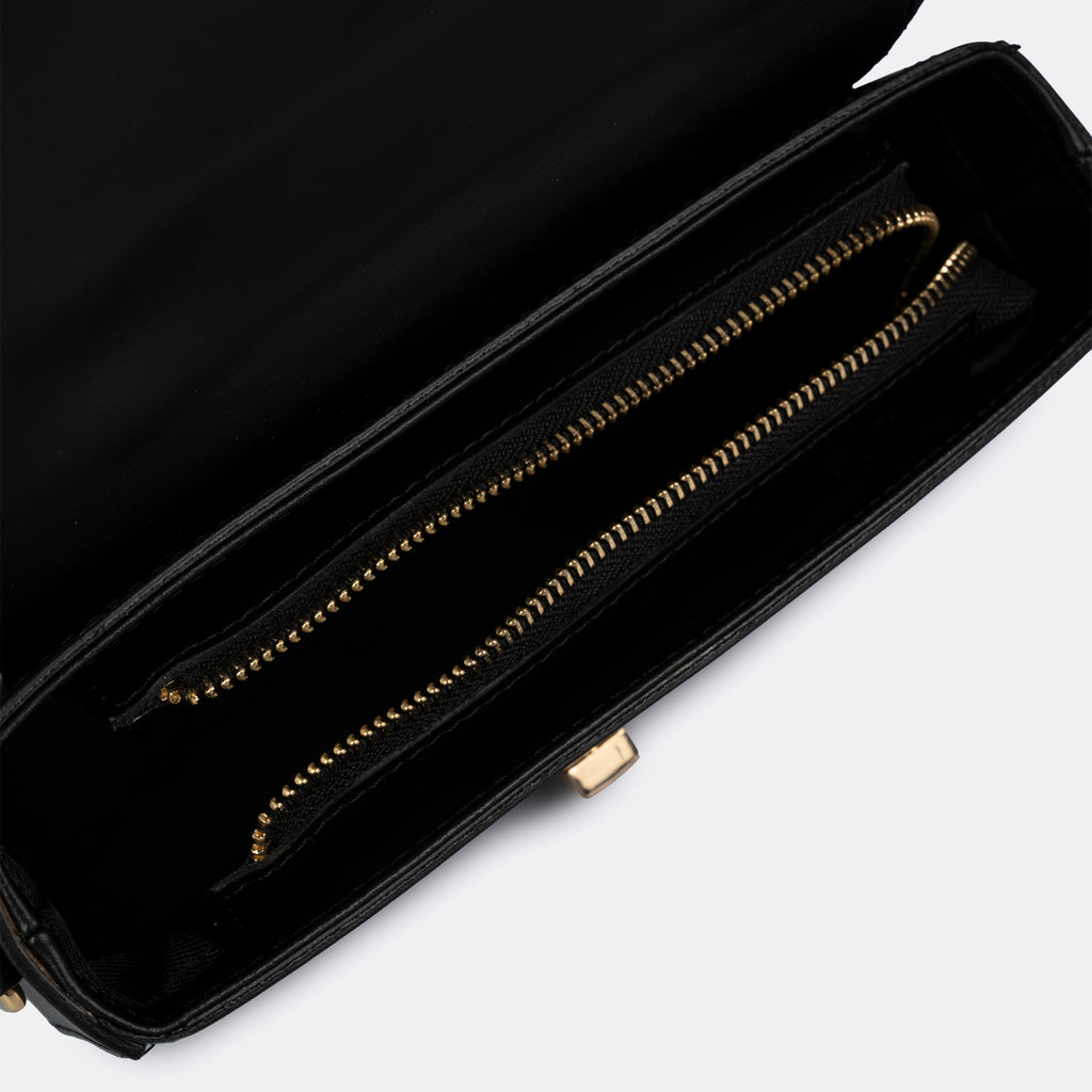 Compact black top-handle bag in Pelle Ruga leather with gold-tone turn-lock bar, the Capri