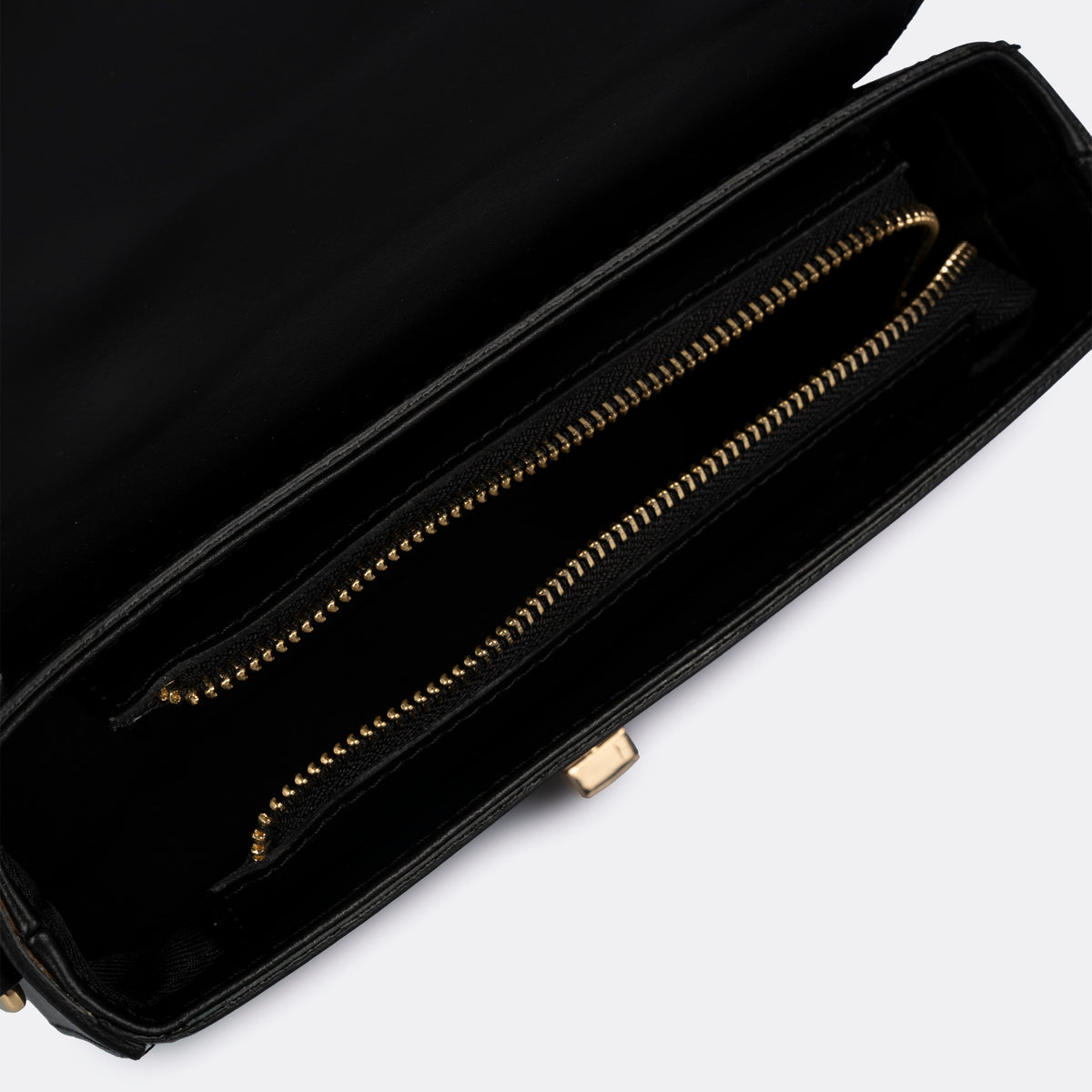 Compact black top-handle bag in Pelle Ruga leather with gold-tone turn-lock bar, the Capri