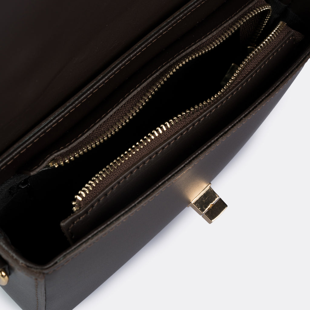 Compact brown top-handle bag in Pelle Ruga leather with gold-tone turn-lock bar, the Capri