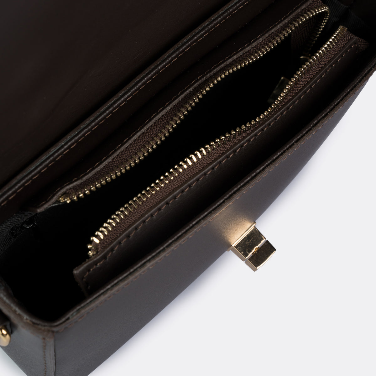 Compact brown top-handle bag in Pelle Ruga leather with gold-tone turn-lock bar, the Capri