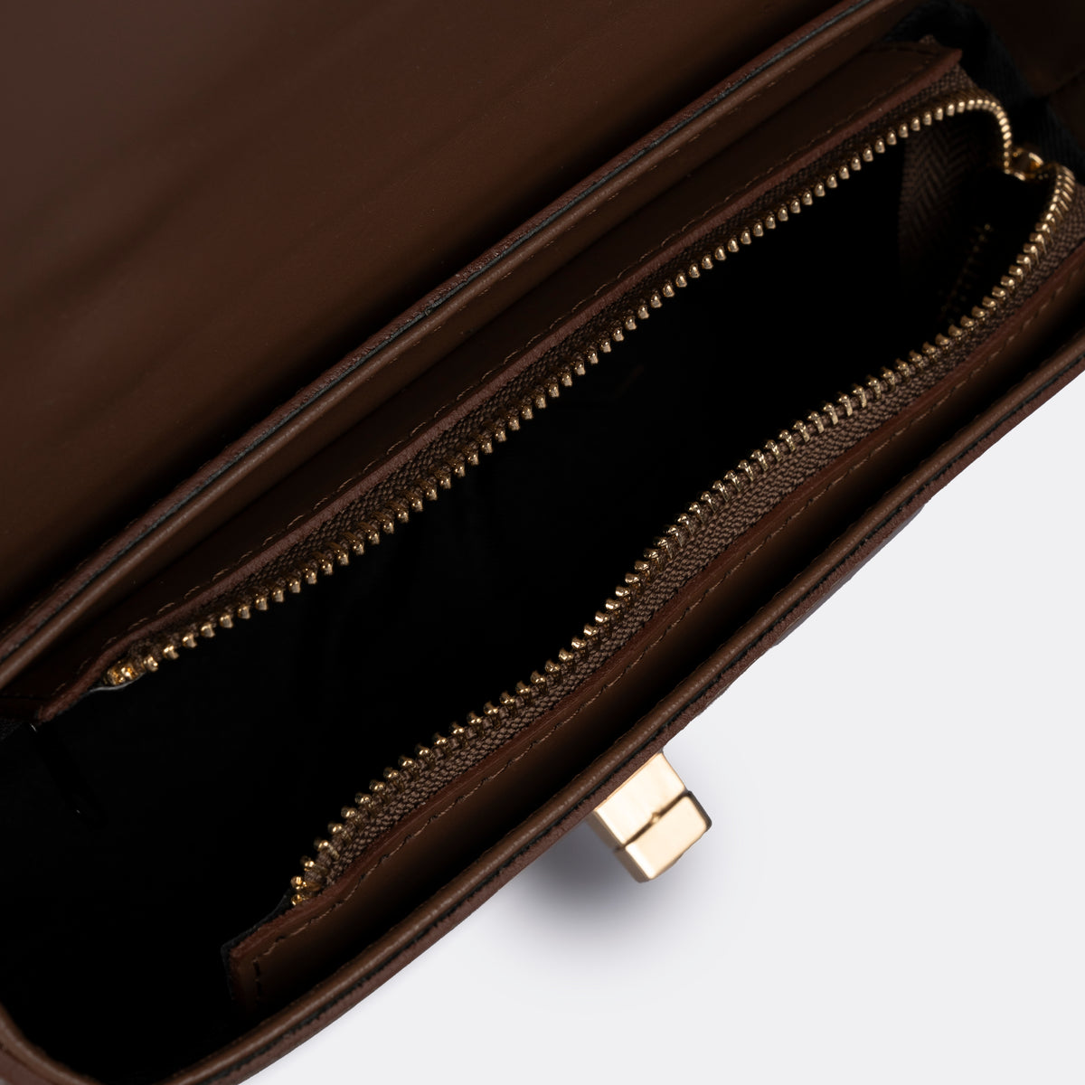Compact cognac top-handle bag in Pelle Ruga leather with gold-tone turn-lock bar, the Capri