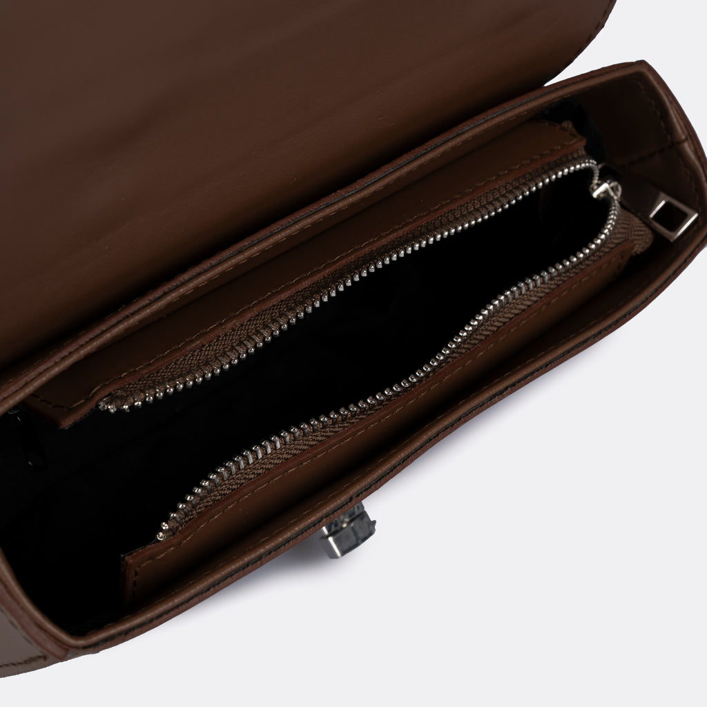 Compact cognac top-handle bag in Pelle Ruga leather with silver-tone turn-lock bar, the Capri