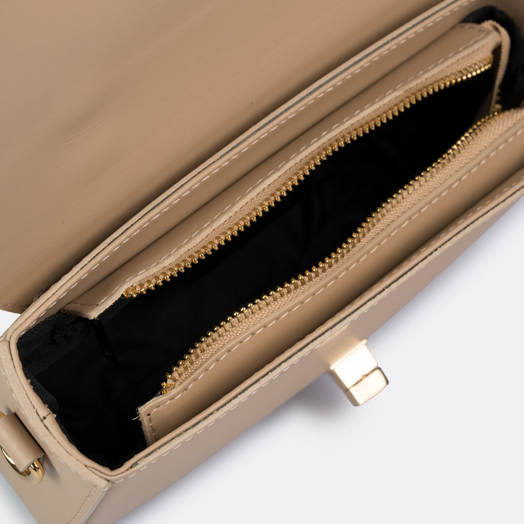 Compact taupe top-handle bag in Pelle Ruga leather with gold-tone turn-lock bar, the Capri
