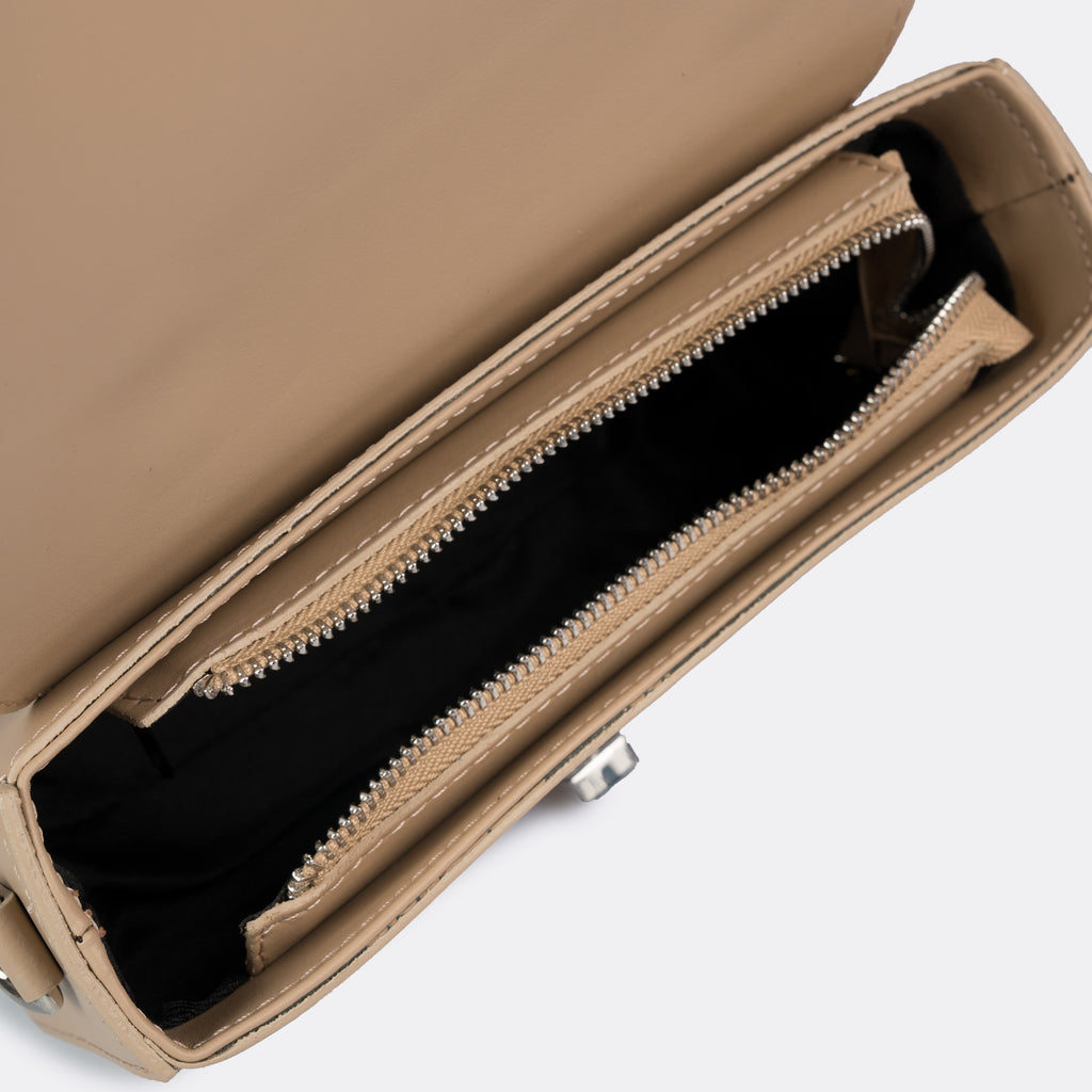 Compact taupe top-handle bag in Pelle Ruga leather with silver-tone turn-lock bar, the Capri